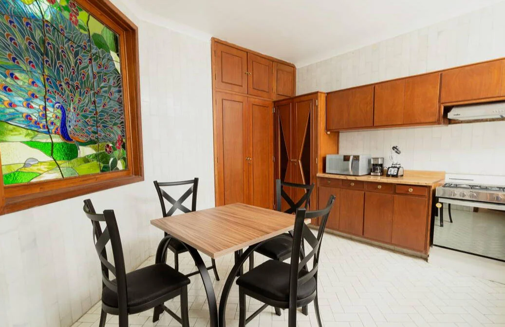 Cocina equipada con comedor y vitral de pavo real